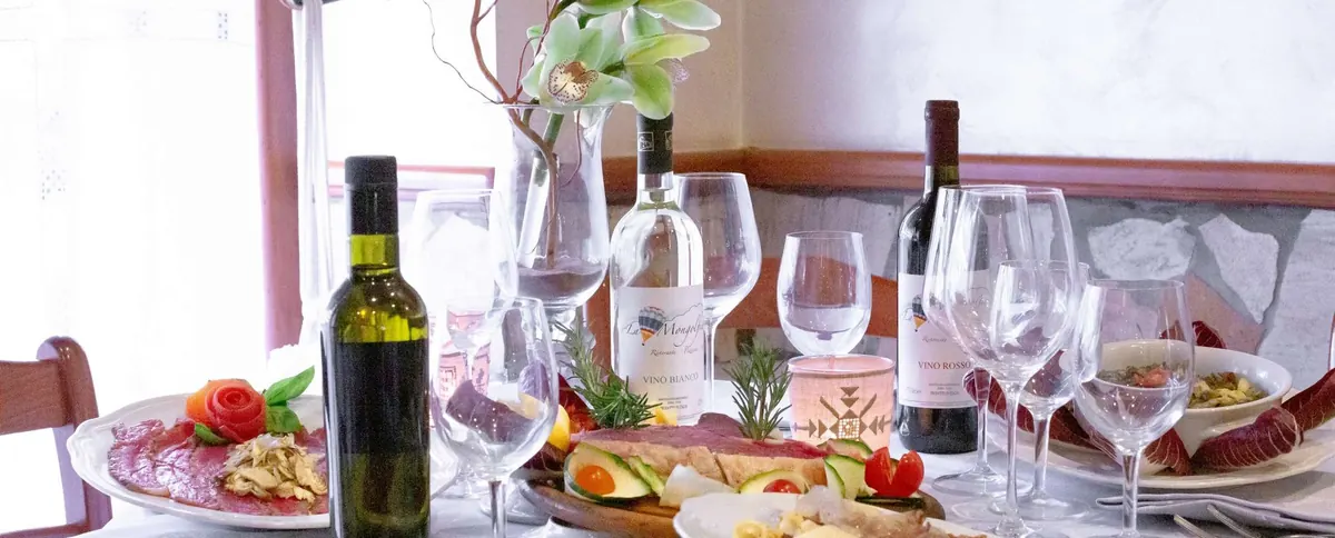 Tavola apparecchiata con vino e calici