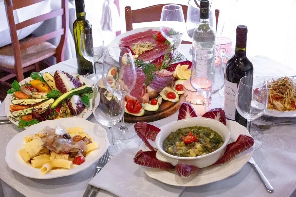 Una tavola con antipasti, primi e verdure